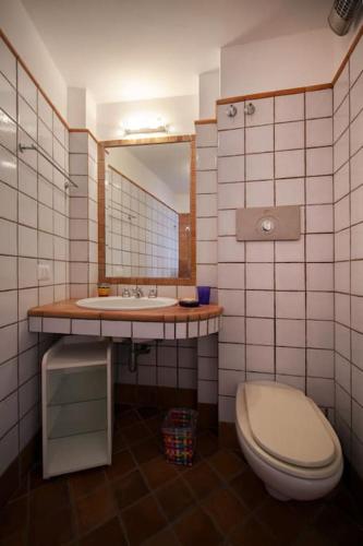 a bathroom with a toilet and a sink and a mirror at La Piccola, Capri in Capri
