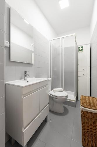 a white bathroom with a sink and a toilet at Consolação Beach Villa in Atouguia da Baleia