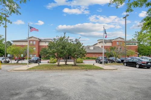 a parking lot with two american flags in front of a building at The Landmark Inn in Fort Bragg