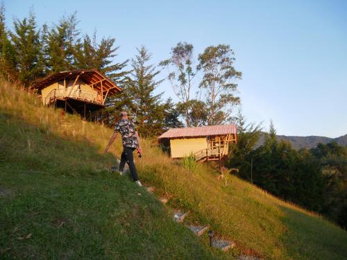 a man walking up a hill in a field at CASA KAYAM Art Hostel Coliving Coworking in Guatapé