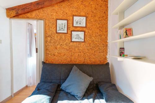 a couch in a room with an orange wall at Naos Casa Vacanze in Iglesias