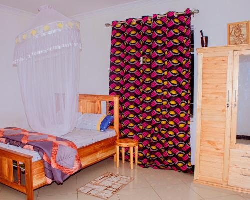 a bedroom with a bed and a shower curtain at Tarangwe Homestay & Hostels in Iringa