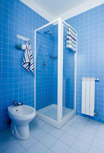 a blue tiled bathroom with a shower and a toilet at Residence Le Terrazze in Trieste