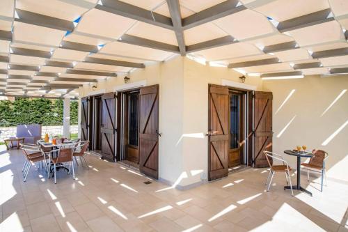 a room with tables and chairs and a ceiling at Villa Drimonas Artemis by Villa Plus in Drymon