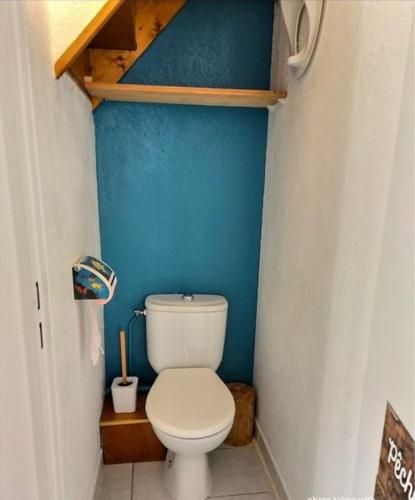 La salle de bains est pourvue de toilettes blanches dans un mur bleu. dans l'établissement Serr, à Valras-Plage