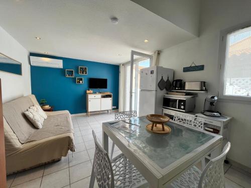 une cuisine et un salon avec une table et un canapé dans l'établissement Serr, à Valras-Plage
