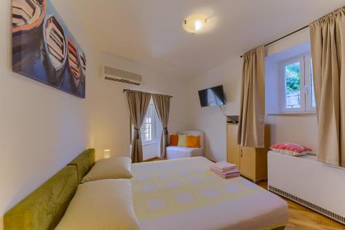 a bedroom with a bed and a couch in it at Guest House City Center in Korčula