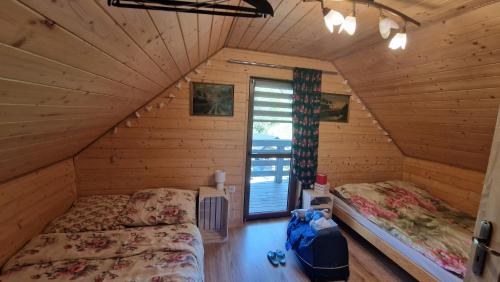 a bedroom with two beds in a log cabin at Domek Dwojakówka in Ropa