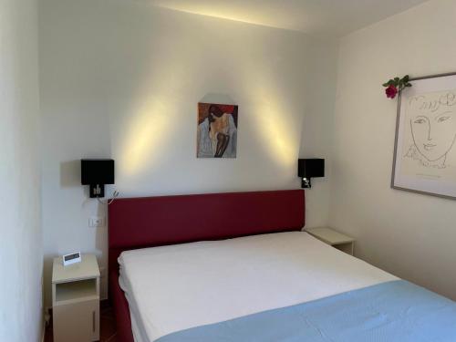 a bedroom with a bed and two lights on the wall at Casa Panorama in Diano Marina