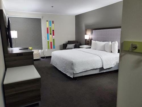 a hotel room with a bed and a chair at Hampton Inn Olathe in Olathe