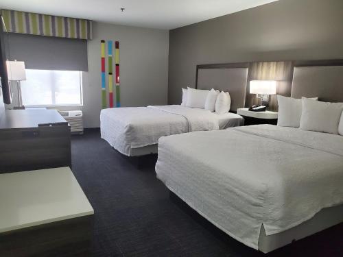 a hotel room with two beds and a window at Hampton Inn Olathe in Olathe