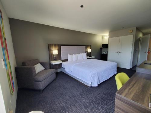 a hotel room with a bed and a chair at Hampton Inn Olathe in Olathe