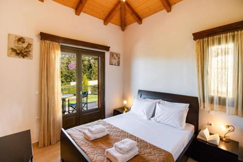 a bedroom with a bed with two towels on it at Villa Drimonas Erato by Villa Plus in Drymon