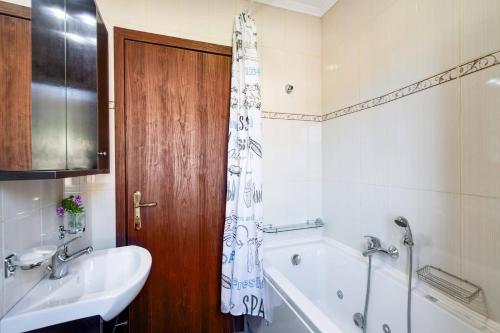 a bathroom with a tub and a sink and a bath tub at Villa Drimonas Erato by Villa Plus in Drymon