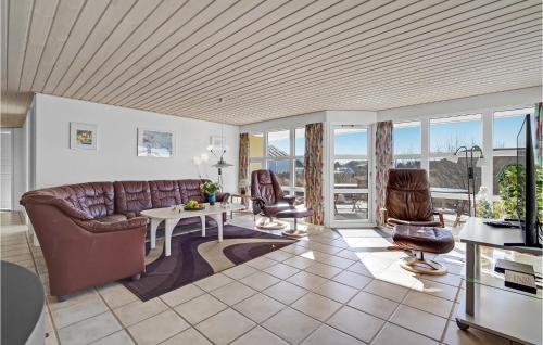a living room with a couch and a table and chairs at Holiday Home Lakolk Iv in Bolilmark