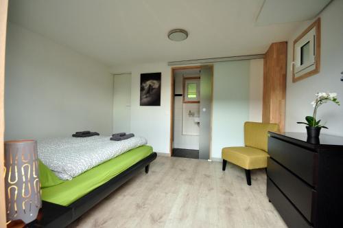 um quarto com uma cama e uma cadeira amarela em Lake View Chalet em Bönigen