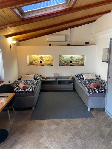two beds sitting in a room with a skylight at Vila Lucia - Apartmán 6 in Plzeň