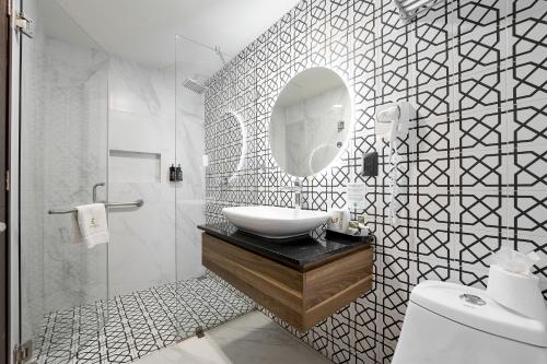 a white bathroom with a sink and a mirror at Hotel Estancia Business Class in Guadalajara