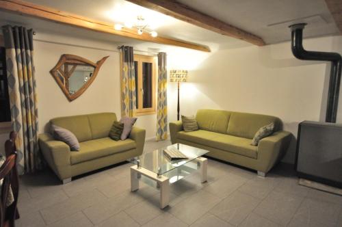 a living room with two couches and a tv at Jungfrau Views Apartment in Interlaken