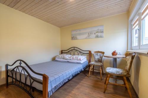 a bedroom with a bed and two chairs and a table at Atokaita in Palanga