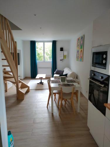 une cuisine et un salon avec une table et des chaises dans l'établissement La petite maison, à Saint-Antonin