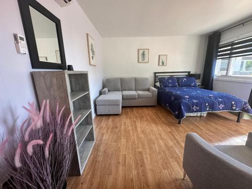 a bedroom with a bed and a couch at Motel de L'Anse et Camping Rimouski in Rimouski