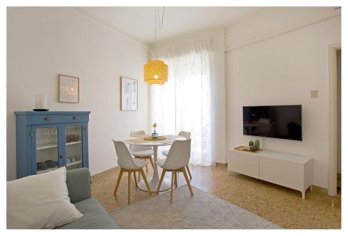 a living room with a table and chairs and a tv at Casa Gorgone, SeaFront Flat! in Viareggio