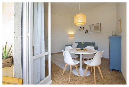 a room with a table and white chairs and a room with a table at Casa Gorgone, SeaFront Flat! in Viareggio