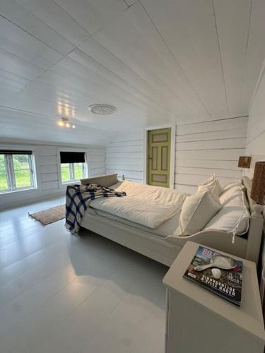 a bedroom with a bed in a room with a table at Sjønært småbruk in Bud