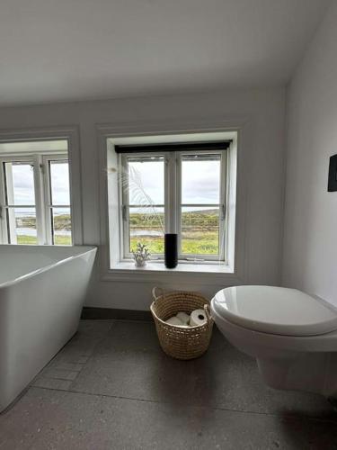 a bathroom with a tub and a toilet and a sink at Sjønært småbruk in Bud