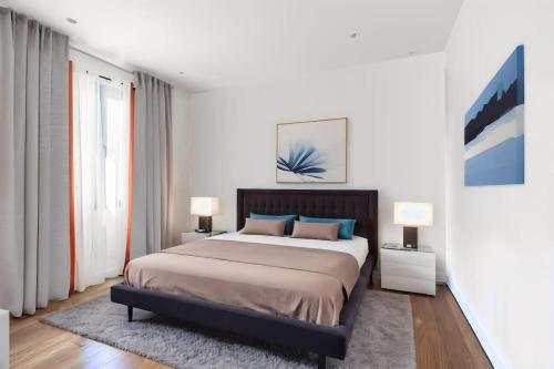 une chambre avec un grand lit et deux lampes dans l'établissement A beautiful house with garden, 7 guests, à Argenteuil