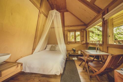 a bedroom with a bed with a mosquito net at Okolin Basoa Suites in Lizaso