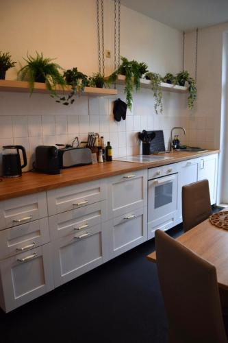 a kitchen with white cabinets and a counter top at charmanter Altbau in Schleußig mit Balkon in Leipzig