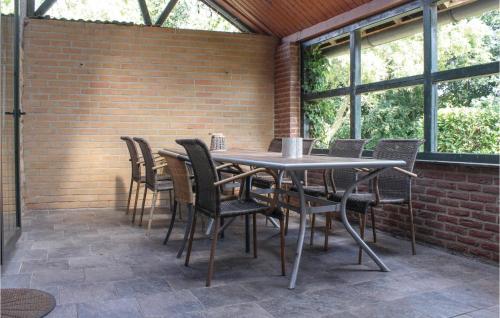 a table and chairs on a patio with a brick wall at Vakantiewoning 1 in Simpelveld