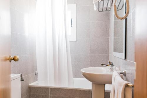 a bathroom with a sink and a shower curtain at Hotel Golf Beach in Santa Ponsa