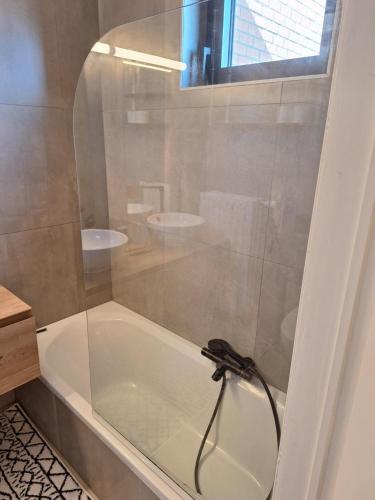 a shower with a glass door in a bathroom at zonnig vernieuwd penthouse dicht bij het strand in Knokke-Heist