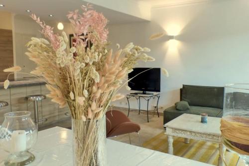 un vase de fleurs sur une table dans le salon dans l'établissement Apartment with beautiful terrace close to the sea, à Six-Fours-les-Plages