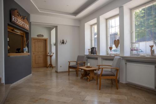 a dining room with a table and chairs and windows at Hotel Gasthof Alter Wirt in Farchant