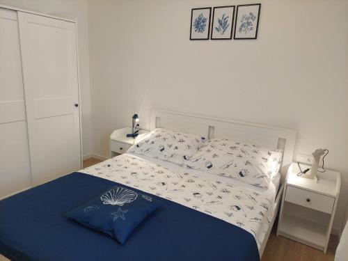 a bedroom with a bed with a blue and white comforter at Apartman Zlata in Pakoštane