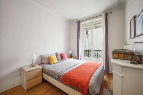 une chambre blanche avec un lit et une fenêtre dans l'établissement Beautiful flat heart of XIVeme, à Paris