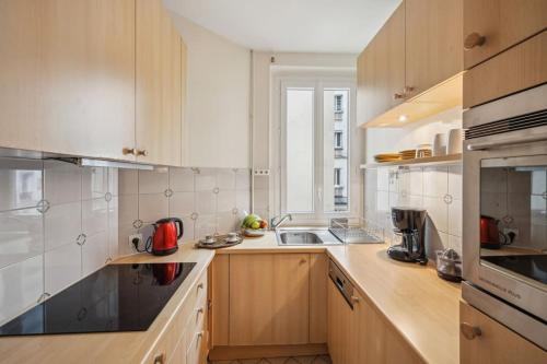 une grande cuisine avec des placards en bois et un évier dans l'établissement Beautiful flat heart of XIVeme, à Paris