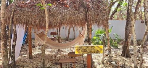 a hammock under a straw hut with a sign at Hotel Kin Tulum Jungle Deluxe in Tulum