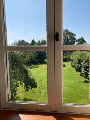 an open window with a view of a green field at Maison d'hôtes La Doucelle culture et bien-être in Lignieres-Orgeres