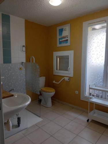 Un baño con lavabo, inodoro y ventana. en Appartement Location saisonnière Résidence ILE D'OR, en La Londe-les-Maures