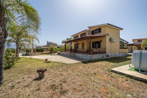 a house with a palm tree in front of it at Villa Panorama in Trappeto
