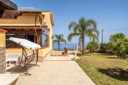 a house with a chair and a view of the ocean at Villa Panorama in Trappeto