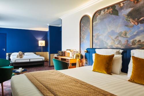 a hotel room with a bed and a painting on the wall at H&ocirc;tel Le Versailles in Versailles