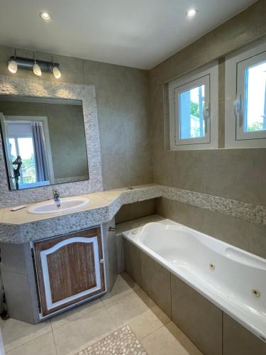 une salle de bain avec une baignoire, un lavabo et un miroir dans l'établissement Luxe et calme avec vue mer panoramique à Antibes, à Antibes