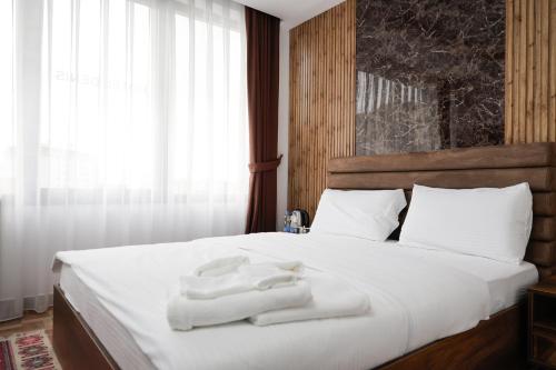 a bedroom with a bed with white towels on it at Hotel Denis in Prizren