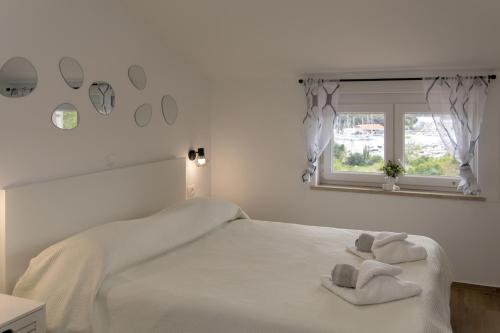 a white bedroom with a bed with towels on it at Apartments Borghese in Pula
